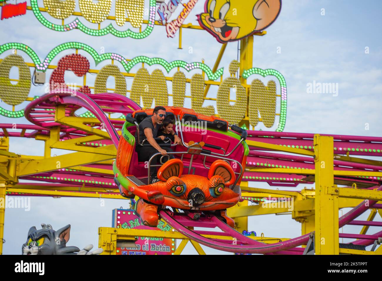 Ragazzo e padre sul punto più alto, spaventato nel giro in macchina delle montagne russe sulla fiera annuale. Funfair. Spagna. Foto Stock