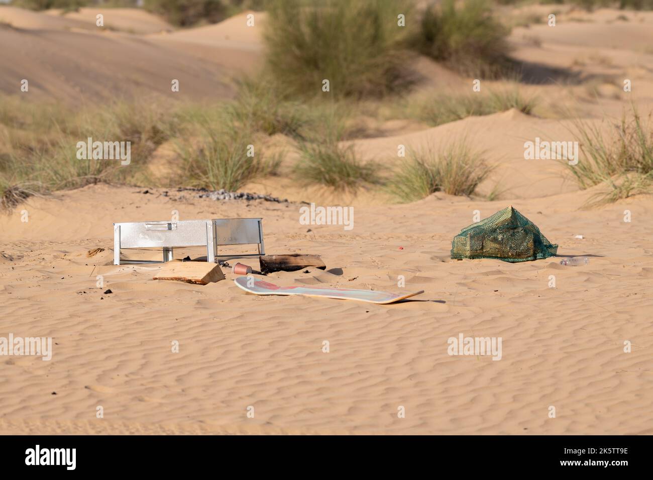 Metallo, plastica e altri rifiuti e rifiuti lasciati da esseri umani inquinando l'ambiente desertico a Dubai, Emirati Arabi Uniti. Foto Stock