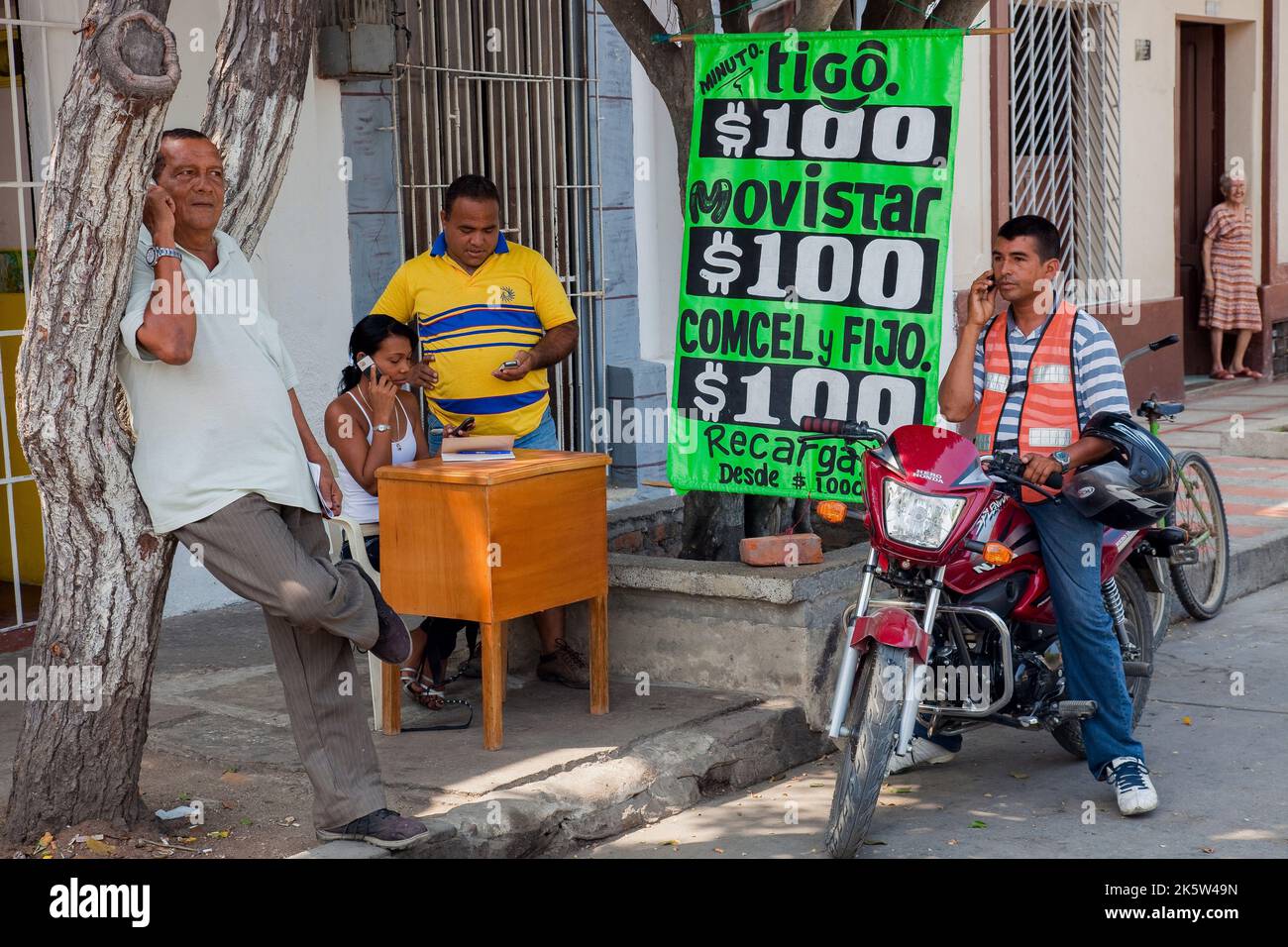 Colombia, sulla piazza centrale una ragazza è uno dei molti che offrono carte telefoniche prepagate, o solo un telefono cellulare per una chiamata, come un boot telefonico pubblico Foto Stock