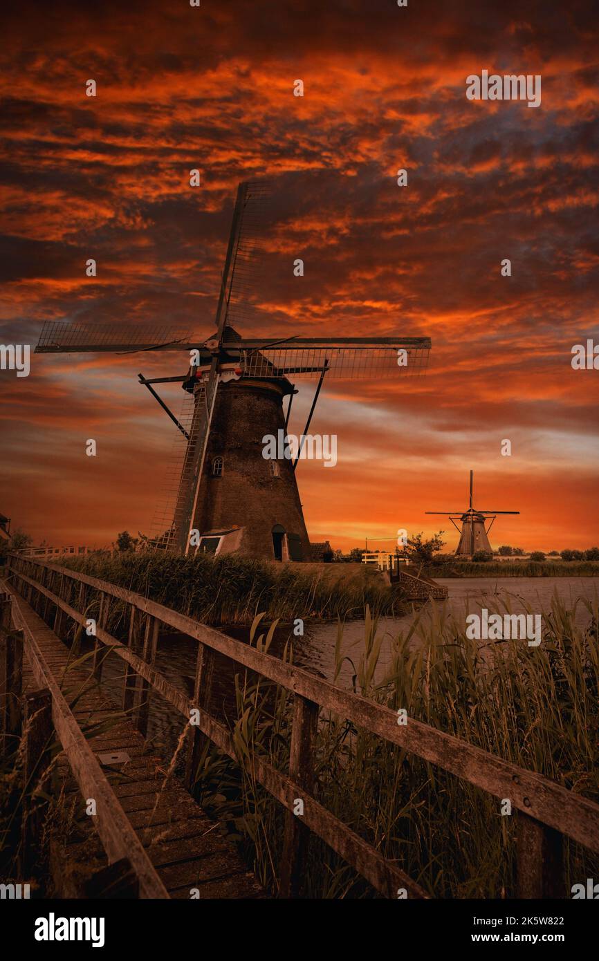 Vecchi mulini a vento a Kinderdijk al tramonto drammatico, in Olanda Foto Stock