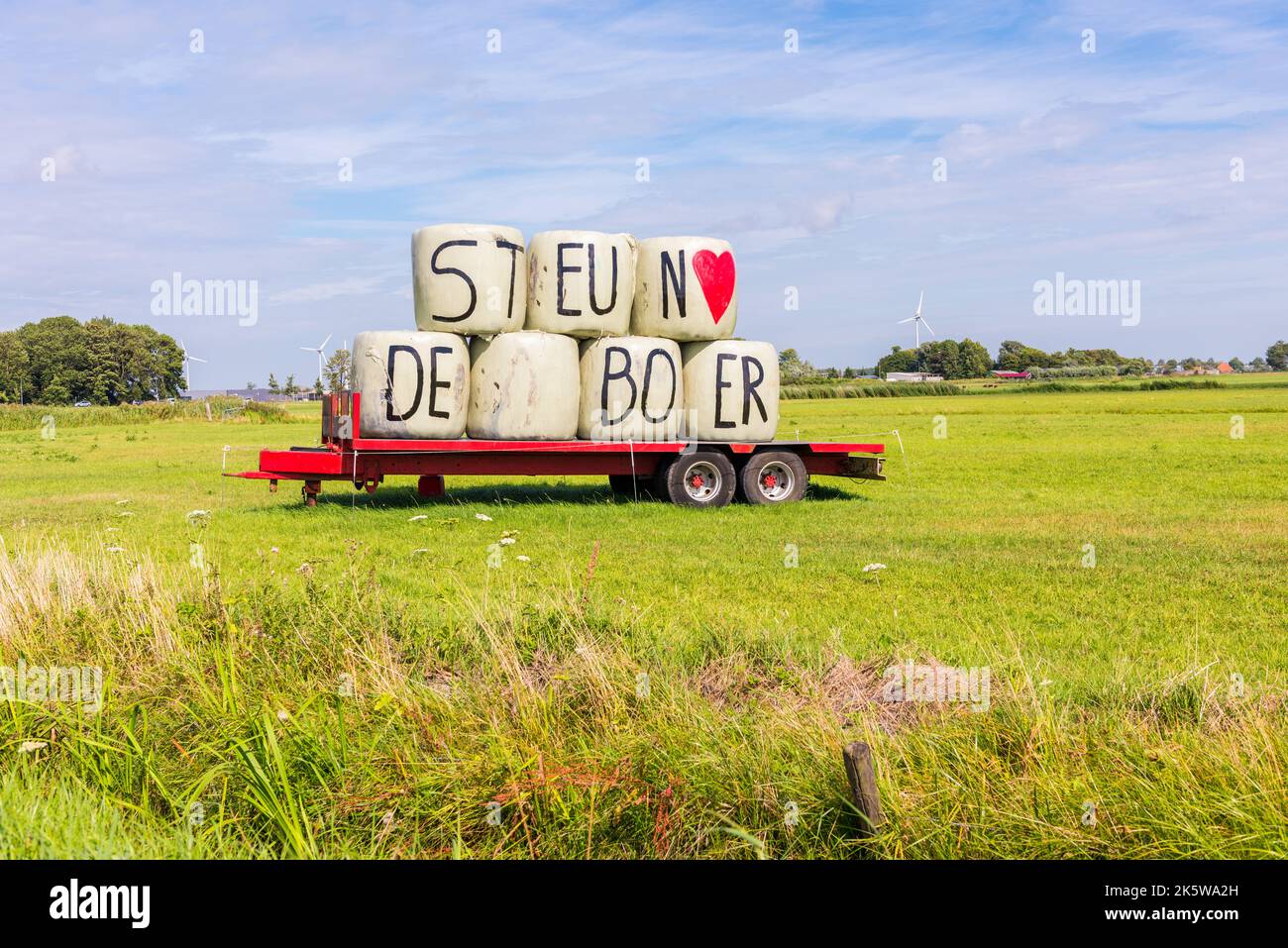 Sostenere le lettere dell'agricoltore sulle balle di fieno sul rimorchio nel prato di Heiloo, Paesi Bassi. Foto Stock