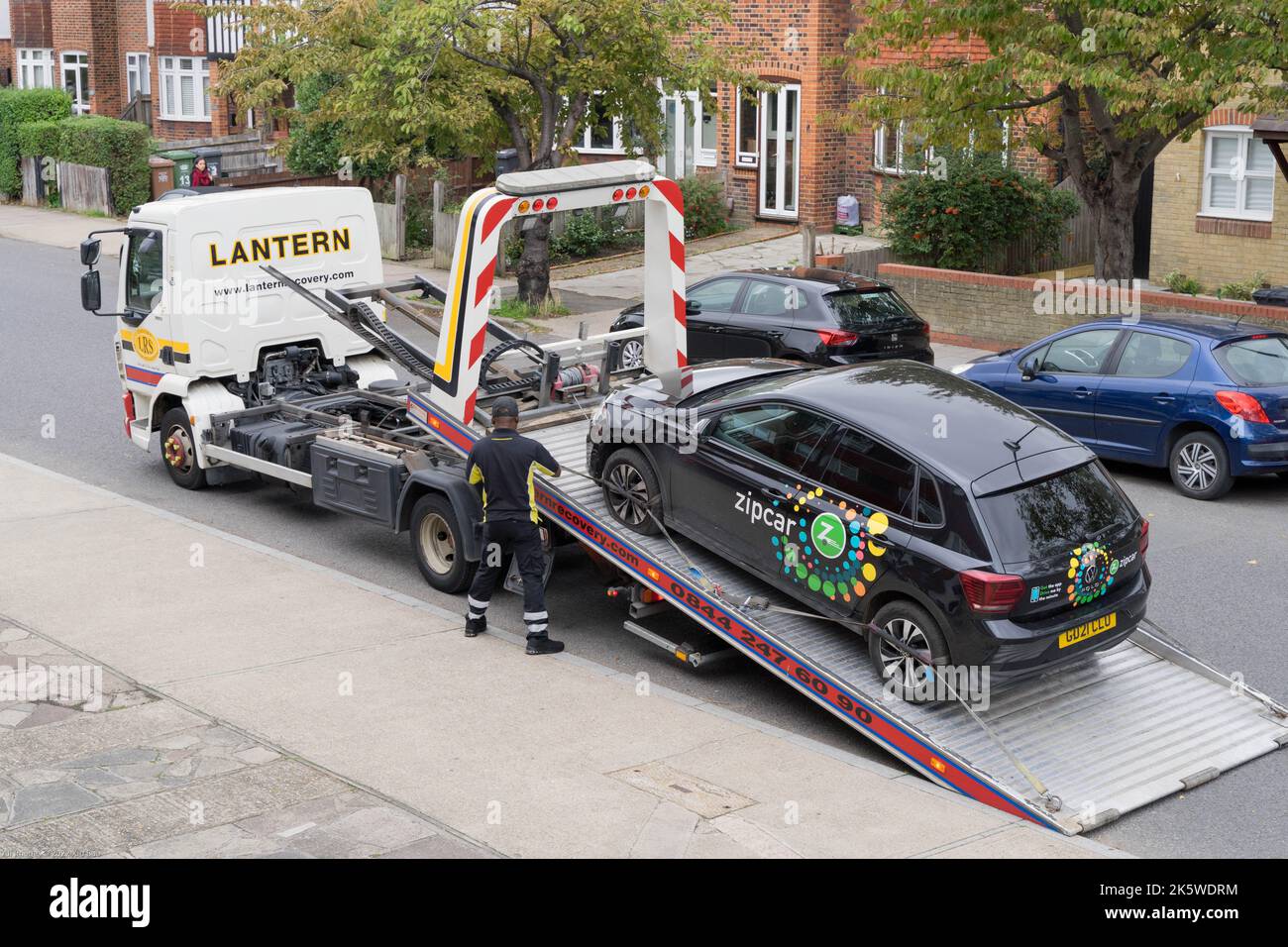 La macchina con zippcar è agganciata su una rampa di carico e fissata su un autocarro di recupero della LANTERNA Londra Inghilterra Europa Foto Stock