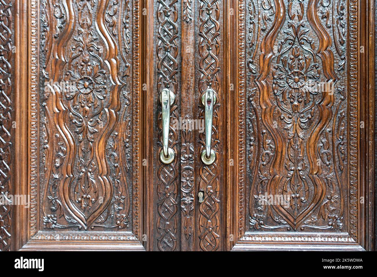 Porte in legno incise di un vecchio armadio classico. Concetto di antiche strutture in legno. Foto di alta qualità Foto Stock