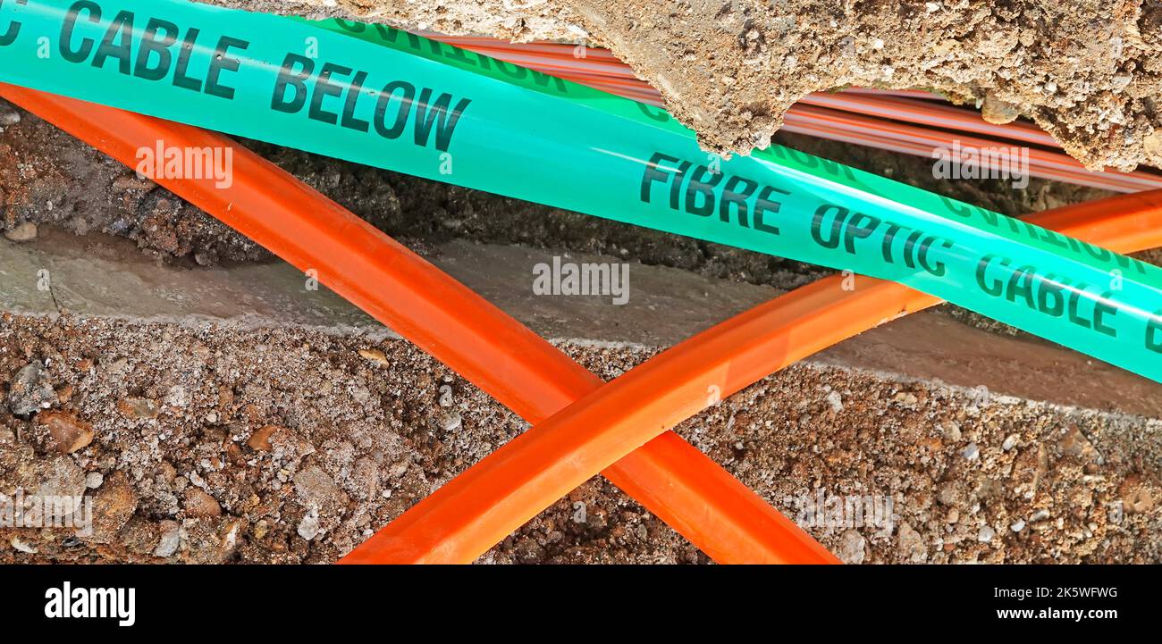 Strade residenziali primo piano lavori in corso di installazione ad alta velocità ultra veloce fibra ottica a banda larga cavo verde plastica avvertimento nastro pavimentazione trench UK Foto Stock