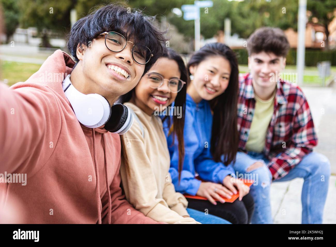 Gruppo internazionale di giovani studenti che prendono selfie con telefono al campus universitario Foto Stock
