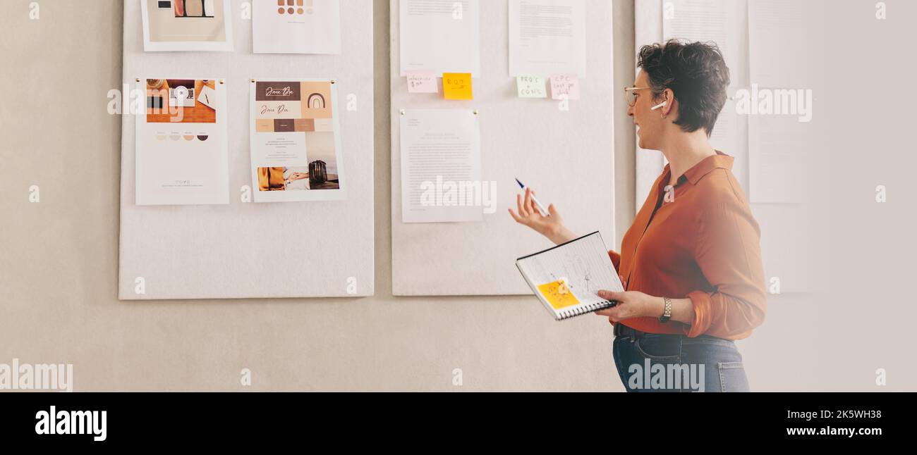 Donna d'affari creativa che presenta il suo lavoro al suo team durante una conference call. Designer femminile che presenta la sua idea in una riunione virtuale. Foto Stock