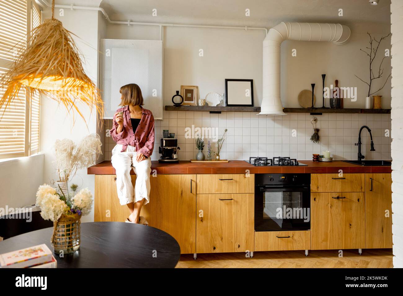 Cucina moderna interna con persona seduta sul tavolo Foto Stock