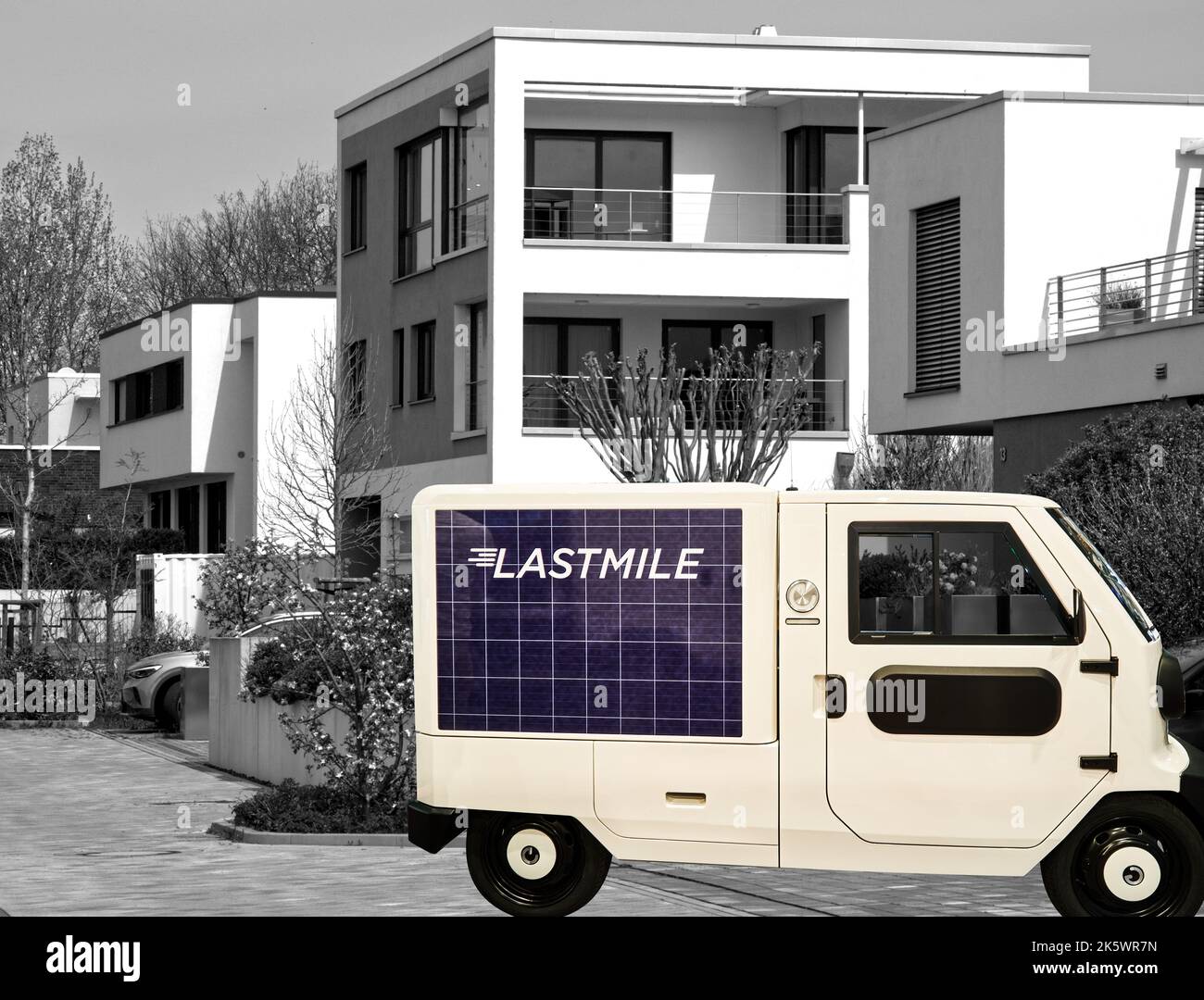 XBus S, minibus elettrico per il trasporto di merci di piccole dimensioni ai consumatori della città, composito di fronte a case di appartamenti cubici minimalistici, Foto Stock