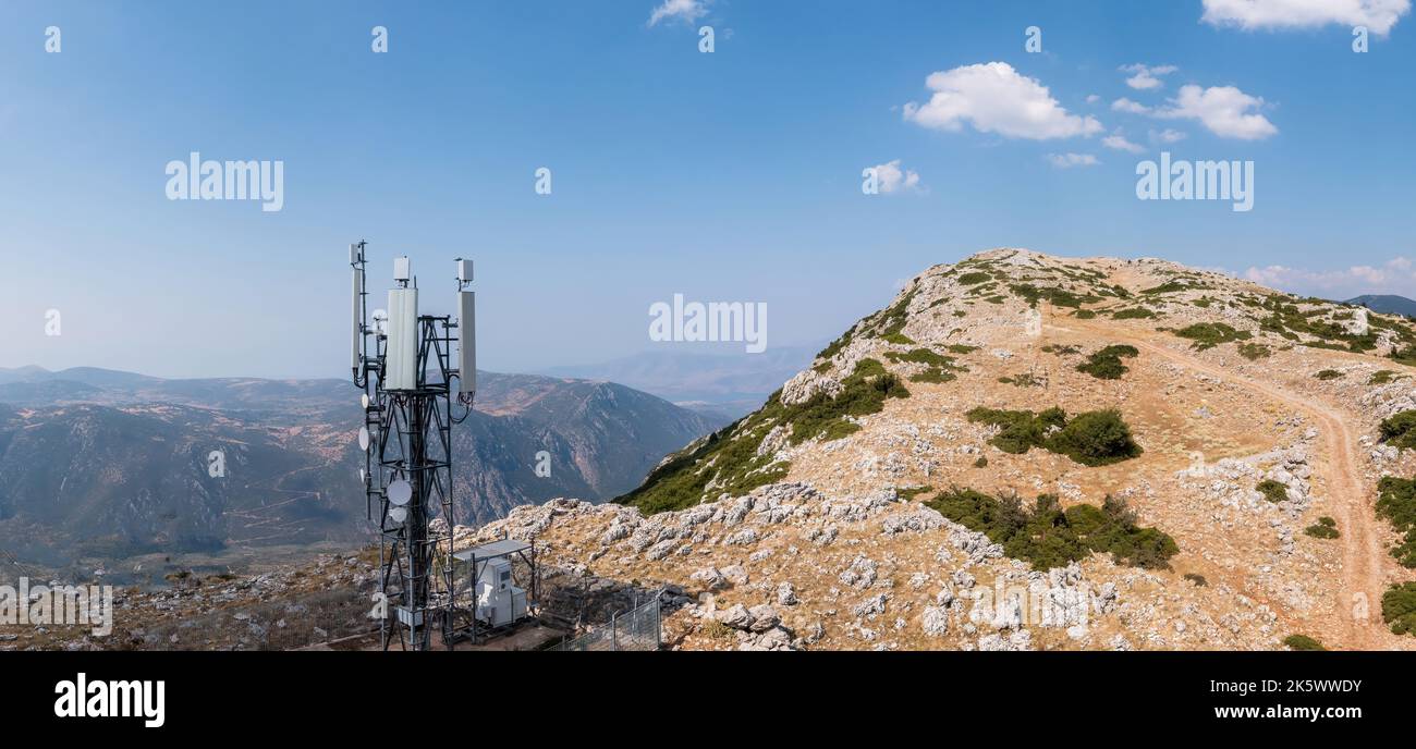 Torre del telefono cellulare. Antenna mobile 5G, radio rete telecom trasmettitore vista antenna. Montagna rocciosa e cielo blu sfondo Foto Stock