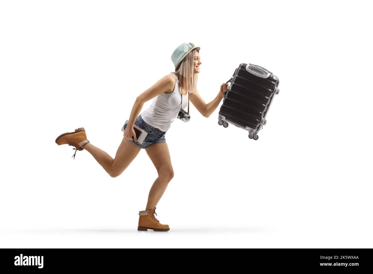 Profilo a tutta lunghezza di una giovane ragazza turista che corre con una valigia isolata su sfondo bianco Foto Stock