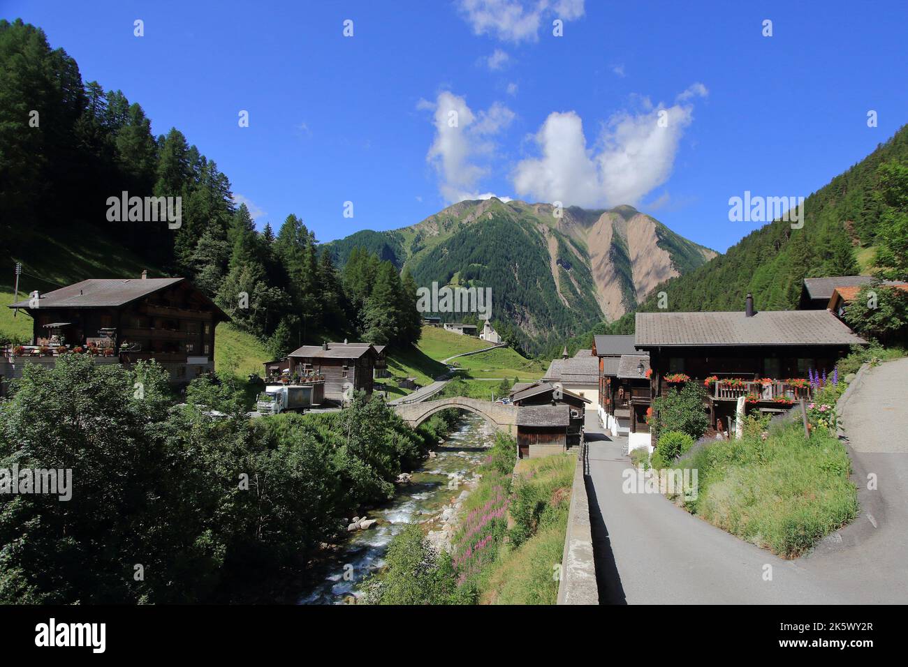 Binn - un piccolo villaggio nel quartiere di Goms nel cantone del Vallese in Svizzera - vista del fiume Binna, ponte Binn, e montagna Breithorn Foto Stock