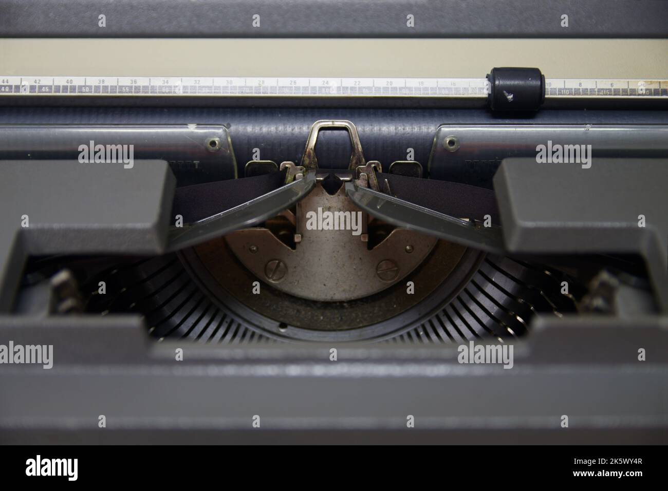 Raffiguri la parte centrale di una vecchia macchina da scrivere in cui spiccano la pressa per carta, il rullo, il nastro di una macchina da scrivere manuale Foto Stock