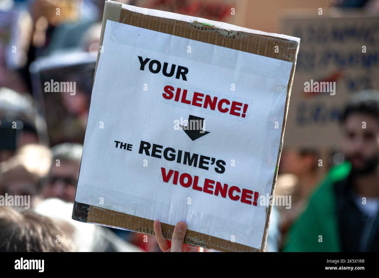 Un manifestante ha un cartello che recita: “Il vostro silenzio, la violenza del regime” durante la manifestazione a Malieveld, l’Aia. Gli iraniani e i loro sostenitori hanno riunito centinaia di persone forti all'Aia, a sostegno degli iraniani che protestavano per le strade dell'Iran. Le forze di sicurezza iraniane hanno violato i manifestanti dopo l'arresto e la morte improvvisa di Mahsa Amin, 22 anni, e Nika Shakarami, 17 anni; arrestati durante un demo di protesta, per Mahsa Amin. Amin, è stato arrestato dalla polizia morale per l'uso improprio del suo hijab -Headsciarf. La polizia ha affermato che ha subito un arresto cardiaco whi Foto Stock