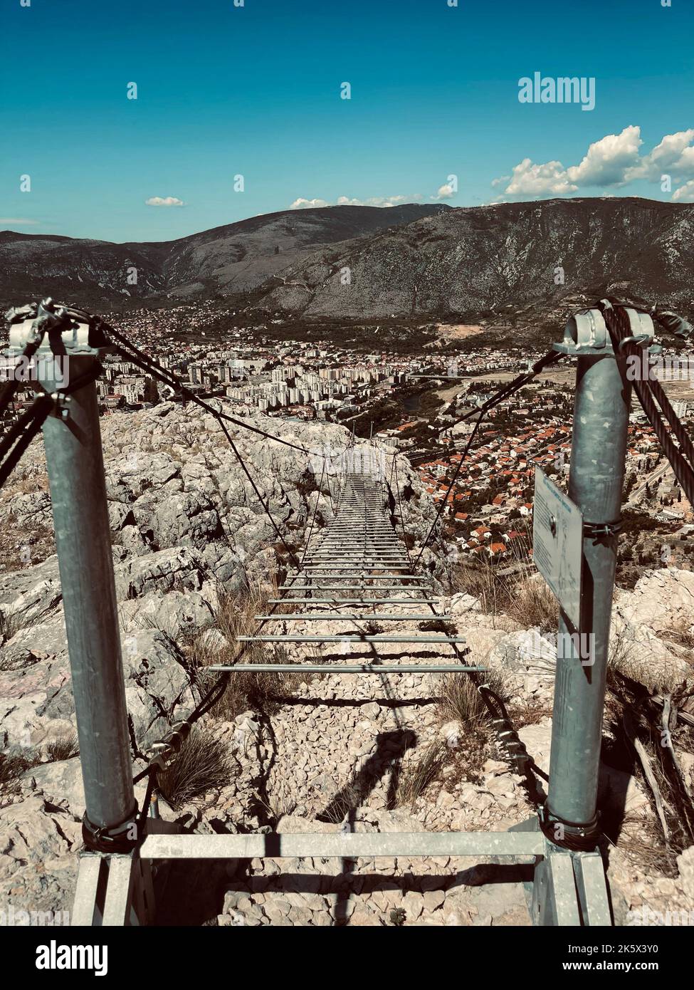 Uno scatto verticale di un vecchio ponte rustico sulle colline rocciose Foto Stock