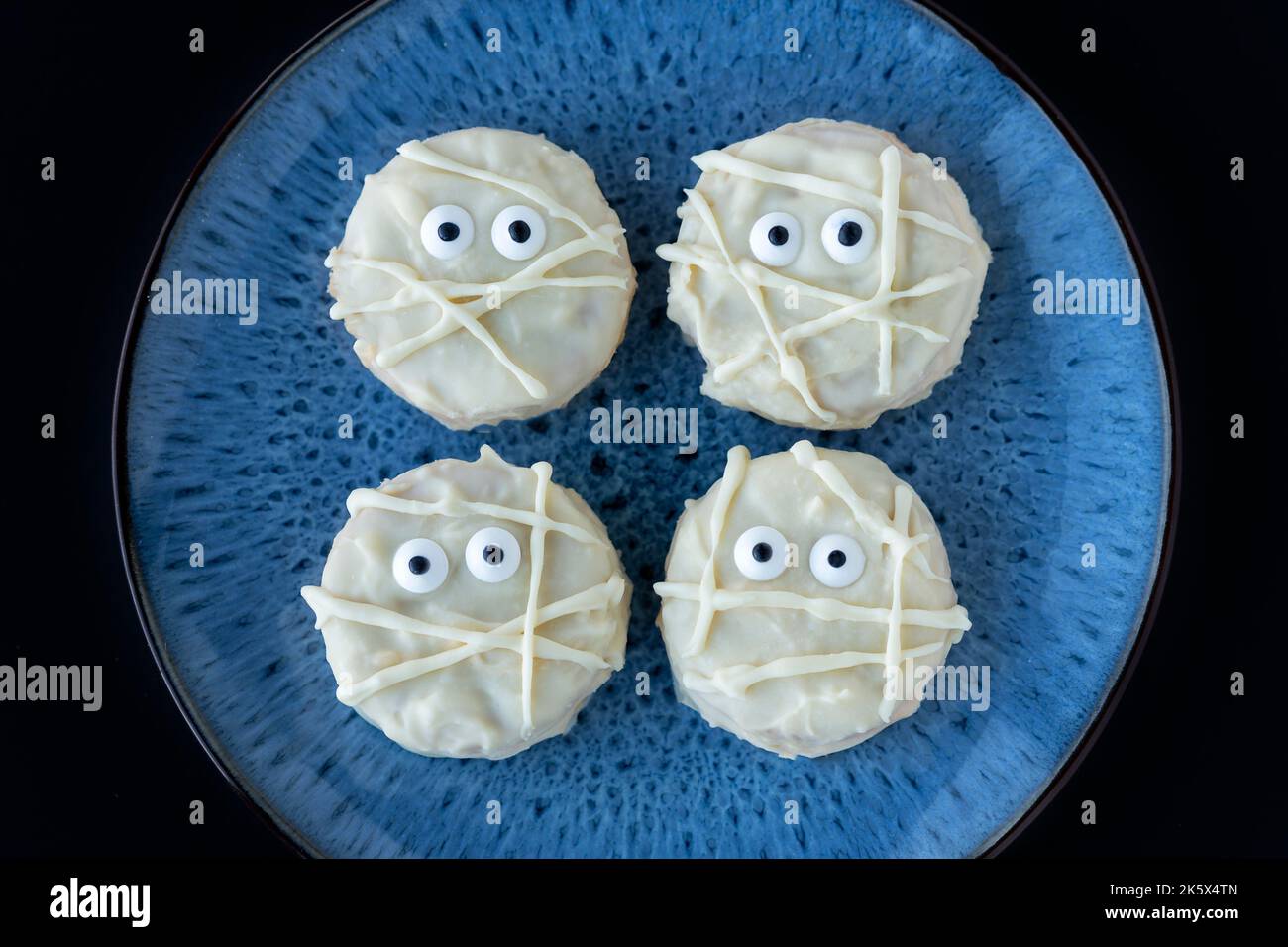 Biscotti di mummia egiziana spoky. Le delizie di Halloween sono fatte in casa utilizzando cioccolato bianco fuso su biscotti Oreo. Gli occhi commestibili completano i biscotti Foto Stock