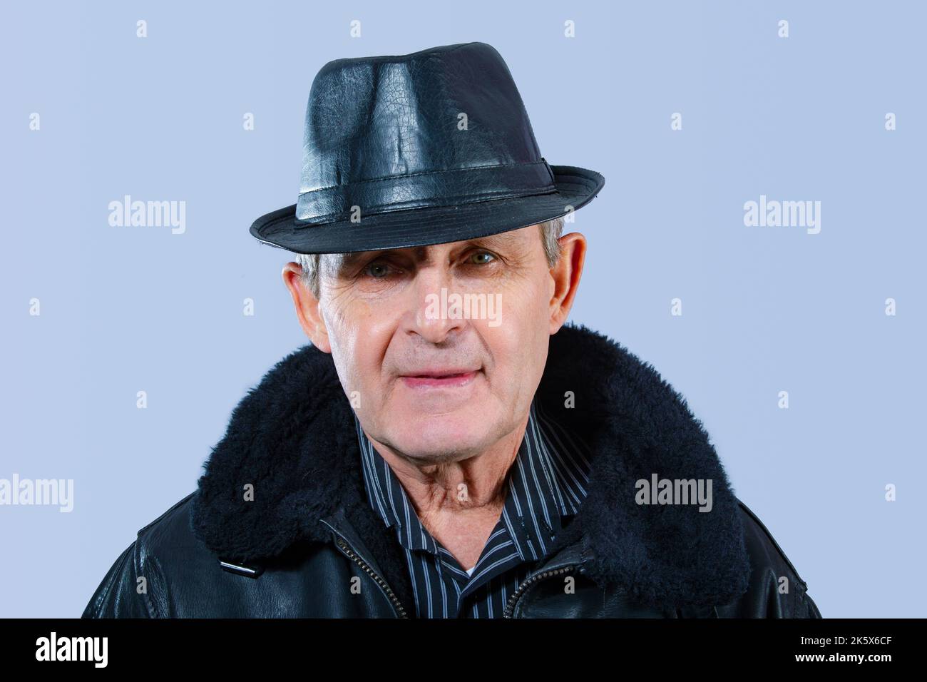 attraente uomo anziano con giacca e cappello in pelle nera Foto Stock