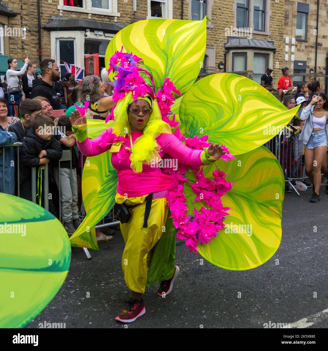 Donna in costume colorato fiore a Leeds West Indian Carnival Parade Foto Stock
