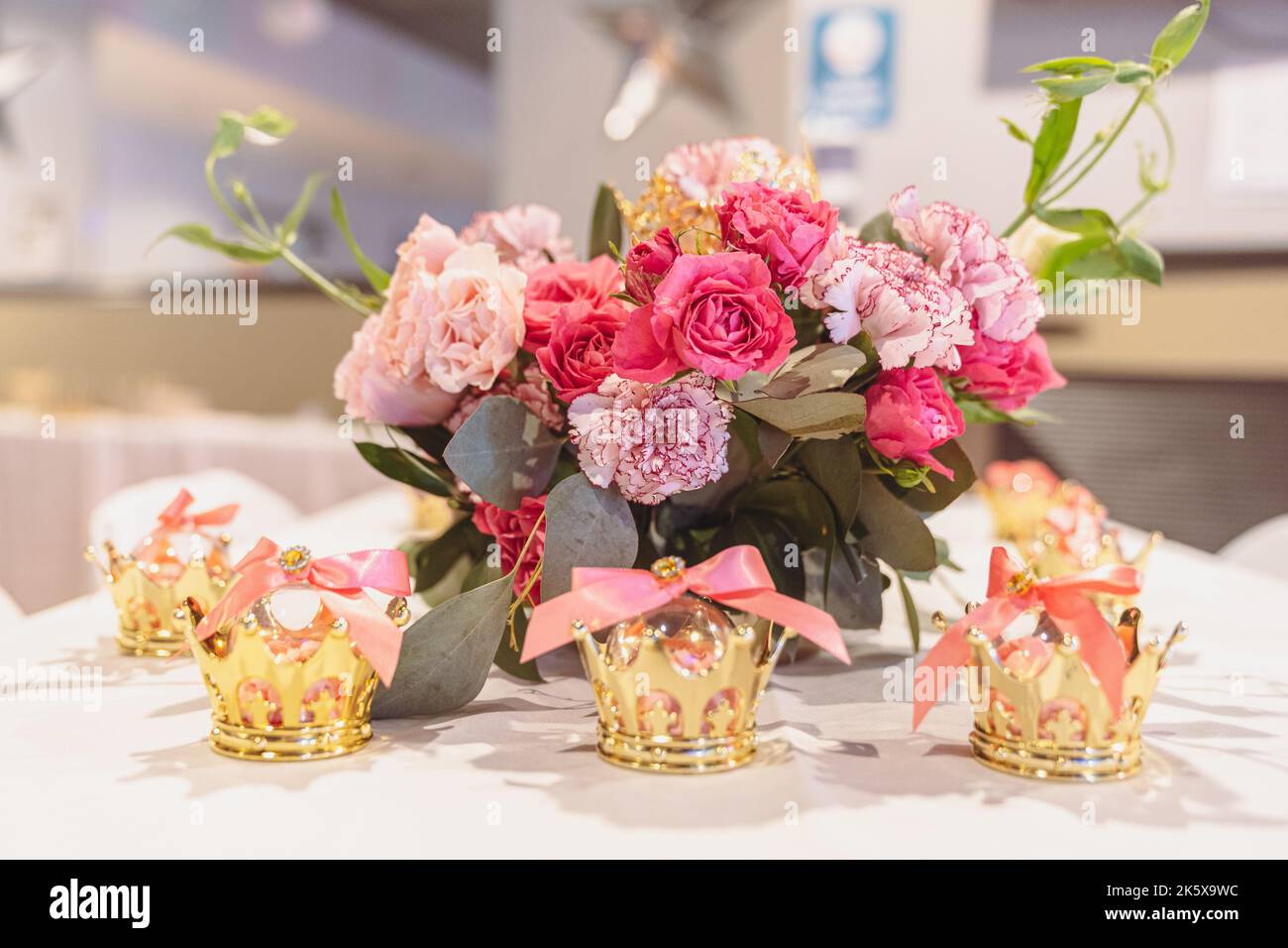 Elegante bouquet di fiori in vaso con bomboniere Crown Party color oro. Foto Stock