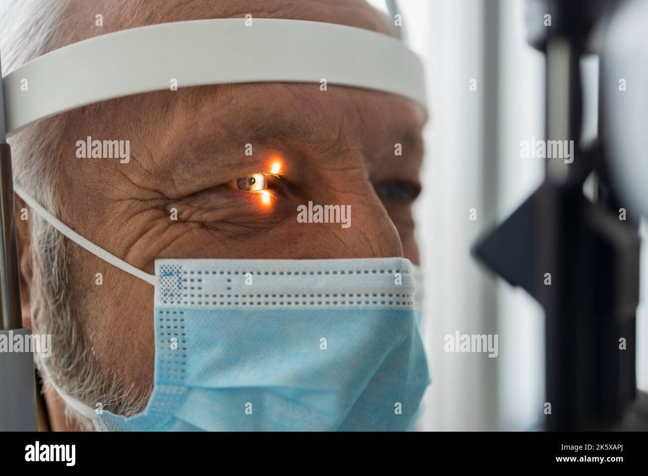Un uomo anziano durante un esame ottico professionale Foto Stock