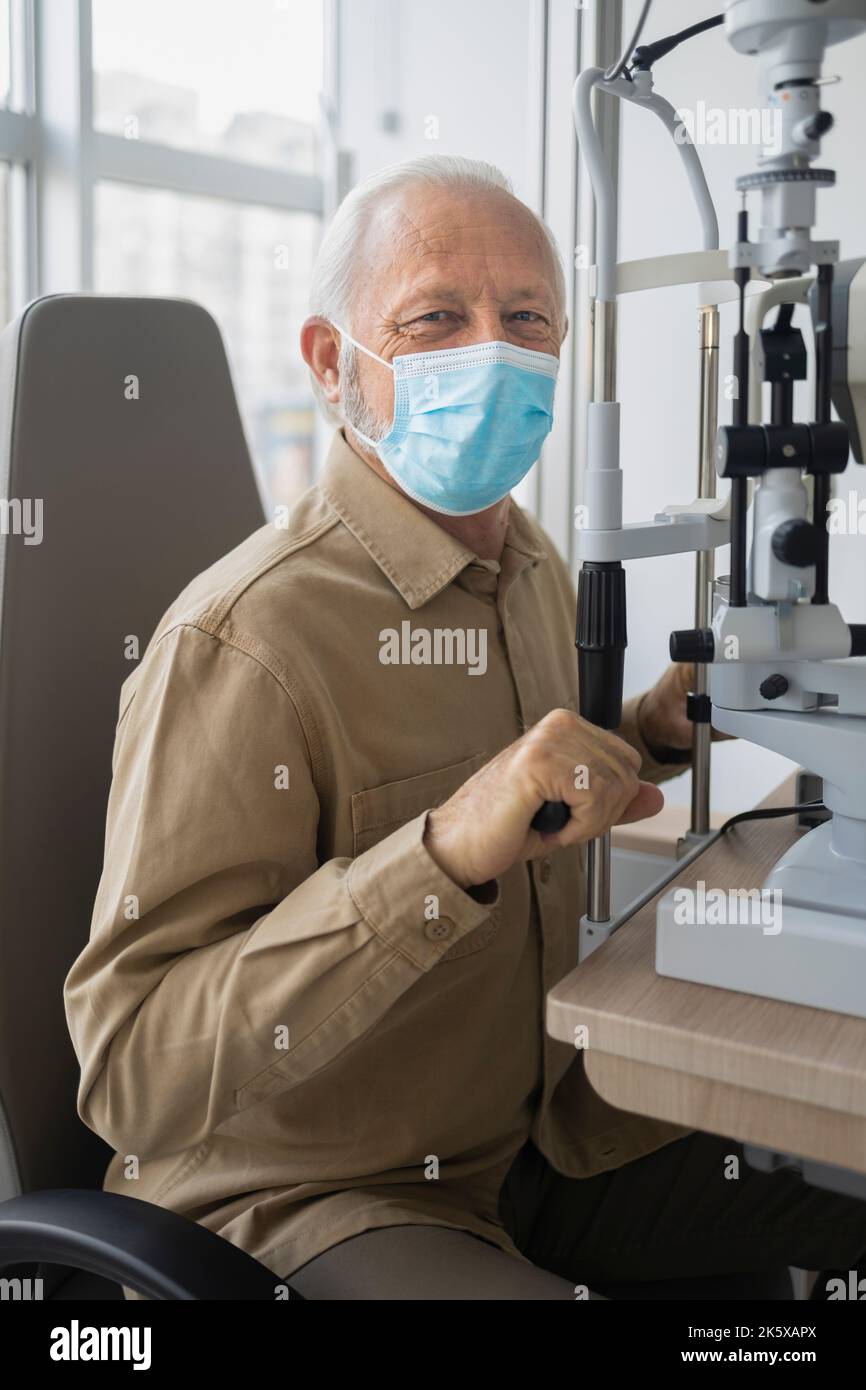 Uomo anziano seduto a preparare la salute degli occhi di check-up Foto Stock