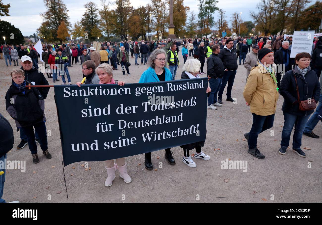 Schwerin, Germania. 10th Ott 2022. I partecipanti si riuniscono nel vecchio giardino per una dimostrazione contro la politica energetica nel nord-est, un banner recita: "Le sanzioni contro la Russia sono il colpo di morte per la Germania e la sua economia!”. Credit: Bernd Wüstneck/dpa/Alamy Live News Foto Stock