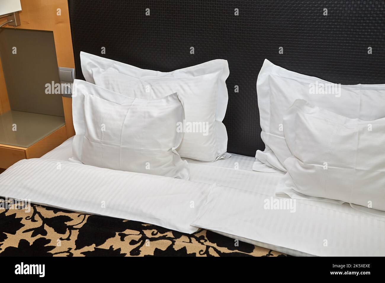 Letto d'hotel con lenzuola bianche Foto Stock