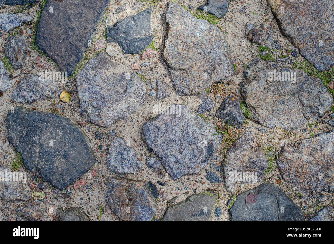 Blocco pietra pavimento struttura sfondo pietra blocco strada pavimentazione. Particolare di strada acciottolata, grunge muro di granito struttura Foto Stock