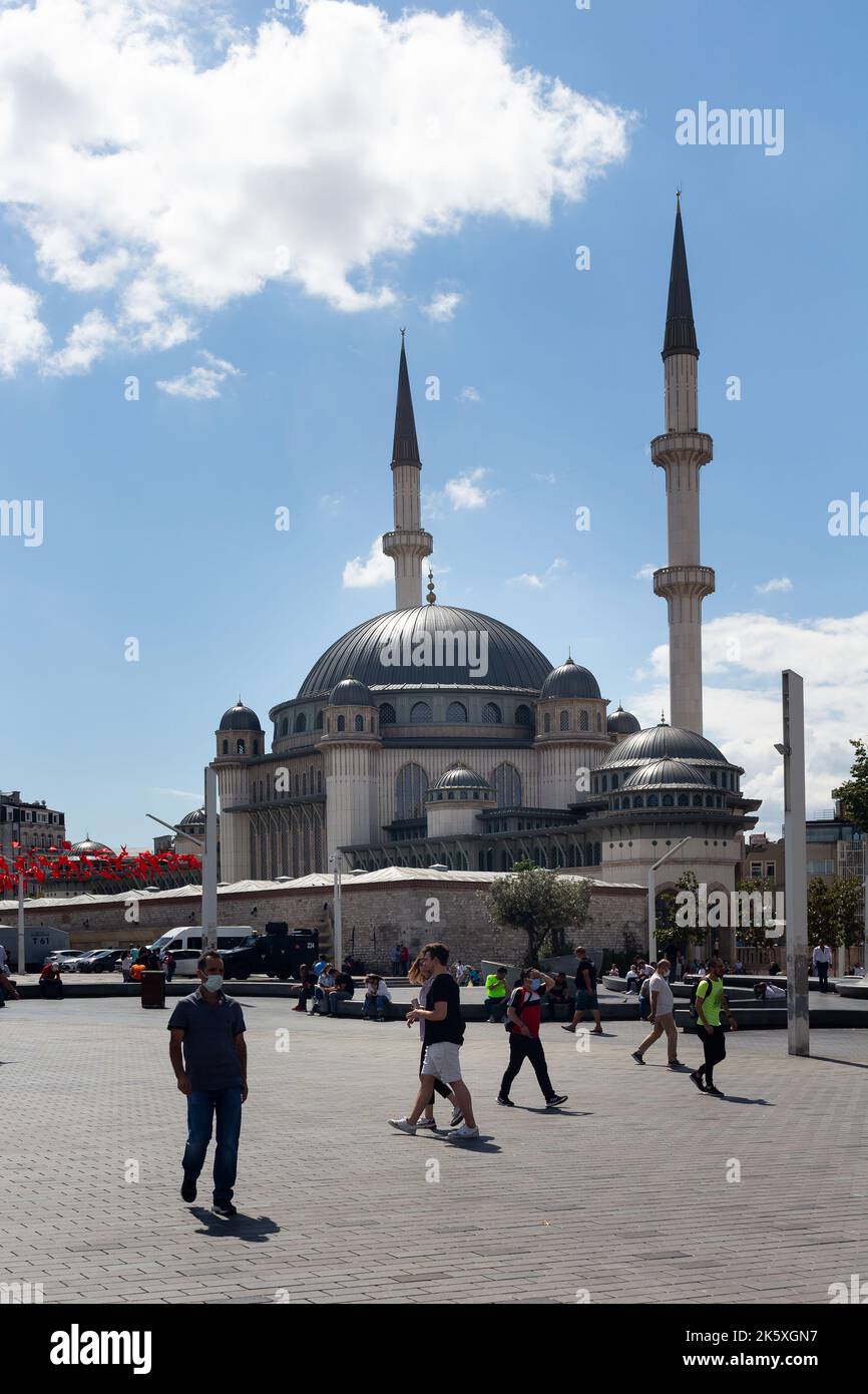 Vista delle persone che camminano in piazza Taksim e della moschea di recente costruzione a Istanbul. E' una giornata estiva di sole. Foto Stock