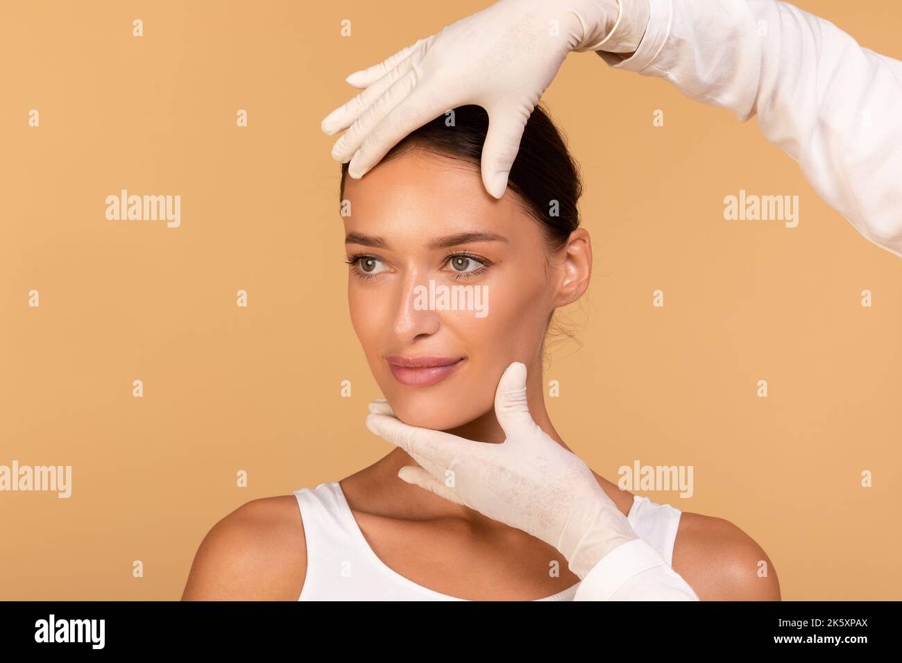 Signora che ottiene il trattamento alla clinica di cosmetology, cambiante il suo aspetto, chirurgo di plastica che tocca il viso femminile bello Foto Stock