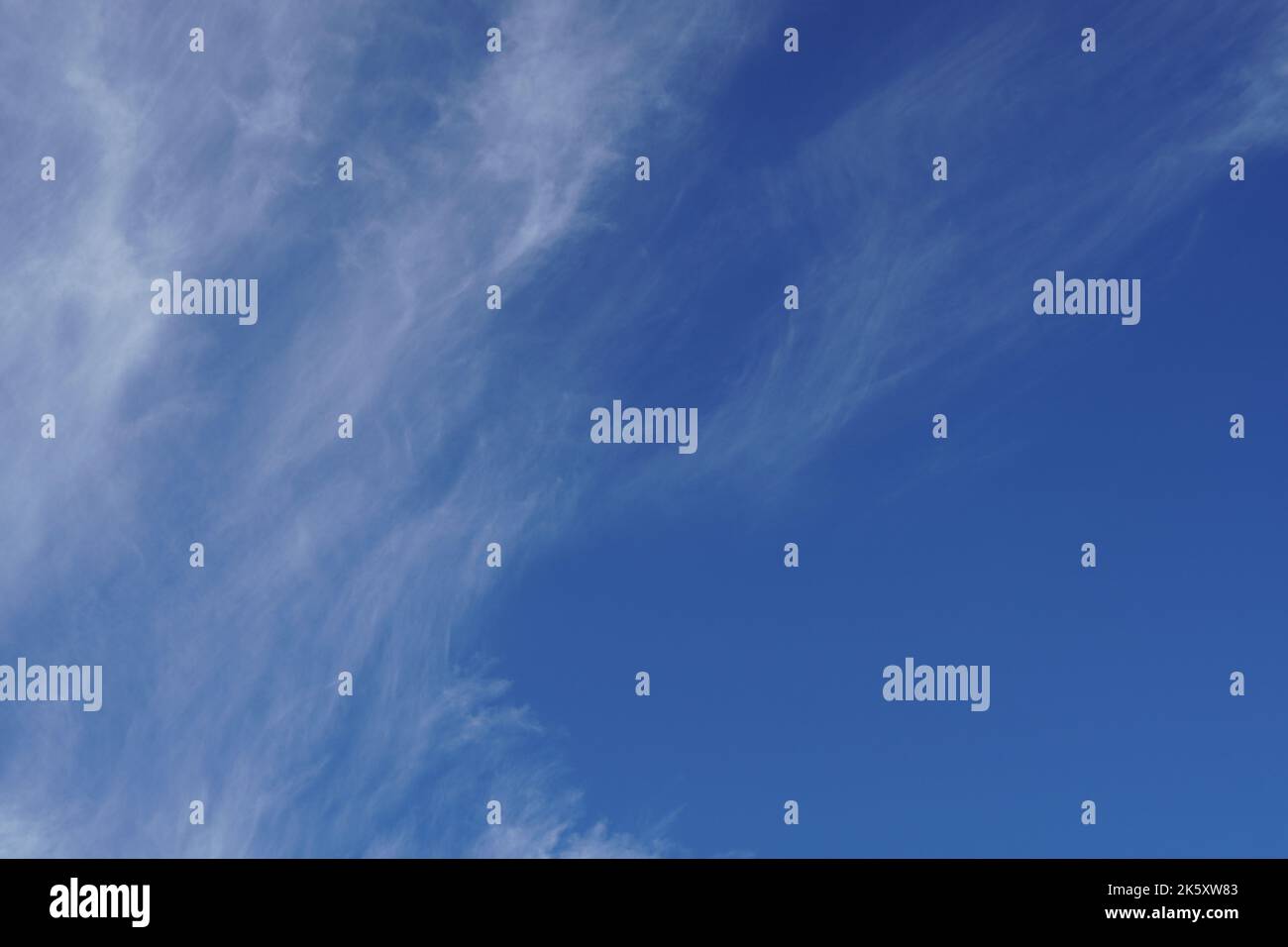 Fine bianco nuvole di cirrus, alto sul cielo azzurro chiaro, nel mese di settembre. Rilassante sfondo tranquillo natura. Foto Stock