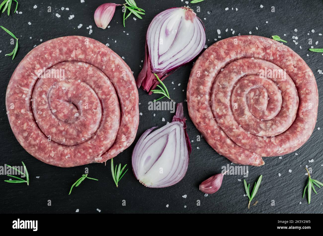 Salsiccia di maiale a spirale su tavola nera Foto Stock