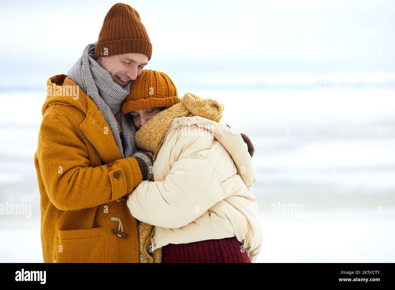Vita in su ritratto di coppia giovane amorevole abbracciare in paesaggio invernale minimo, copia spazio Foto Stock