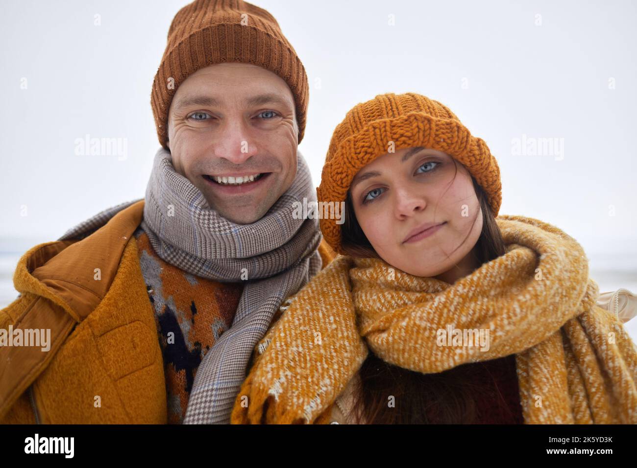 Foto selfie POV di giovane coppia spensierata sorridente alla macchina fotografica all'aperto in inverno, indossando abiti caldi Foto Stock