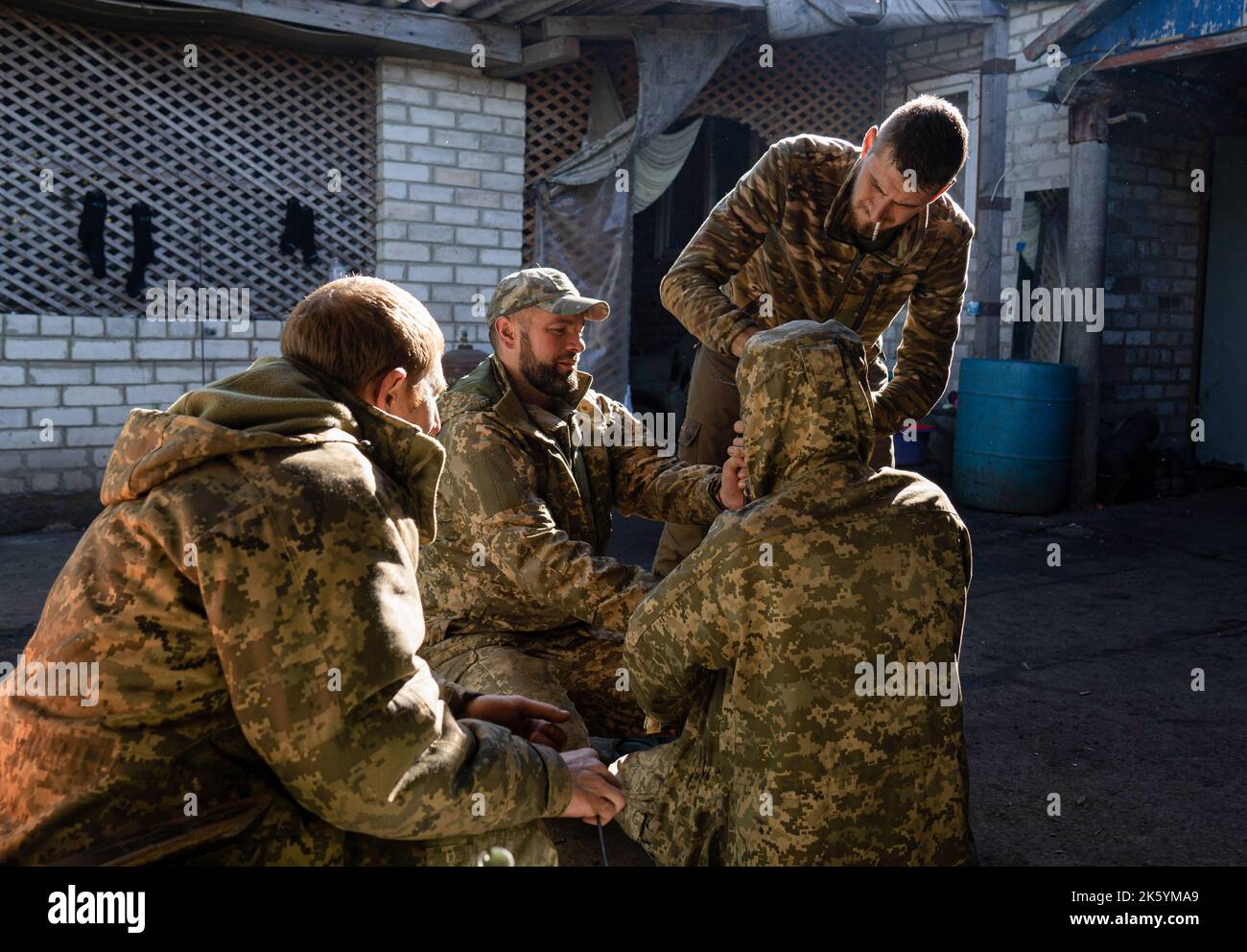 I soldati ucraini hanno visto ripulire la loro pistola a fucile in un insediamento militare nel villaggio di Zelena Dolyna dopo che le forze ucraine si riacquistavano controllate della zona nella regione di Donetsk. Mentre le truppe ucraine continuano il loro avanzamento vicino al confine tra Luhansk, Donetsk e la regione di Kharkiv e la lotta tra i paesi si intensifica, c'è spazio tra pace e guerra. Dal momento che molti civili che risiedevano in questa zona sono fuggiti in mezzo alla battaglia della città Svatove nella regione di Luhansk, molti insediamenti intorno a questo spazio hanno iniziato a diventare 'città fantasma'. La liberazione di Lyman, un strategico Foto Stock