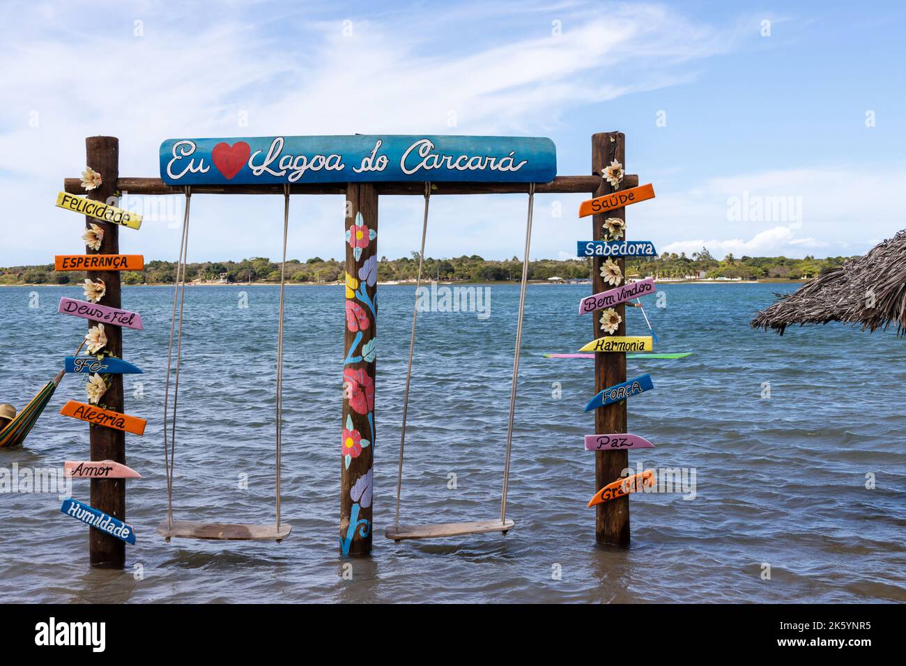 Diversi manifesti con parole in portoghese accanto a due amache nella laguna di Carcara. Parole di buone vibrazioni per le foto turistiche. Foto Stock