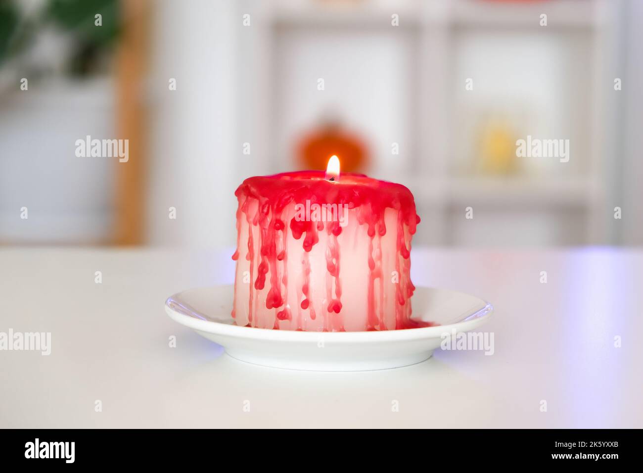 Fai da te Halloween candela bianca di Halloween, coperta di cera rossa come gocce di sangue su sfondo bianco. Idea regalo, arredamento per Halloween. Passo dopo passo. Sanguinoso candele Halloween festa. Officina. Foto Stock