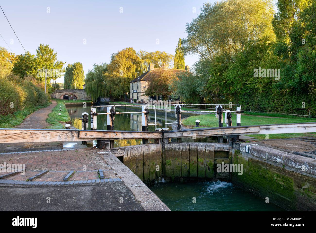 Porta di chiusura del canale e il pub Navigation sul Canal Grande Union in autunno all'alba. Stoke Bruerne, Northamptonshire, Inghilterra. Foto Stock