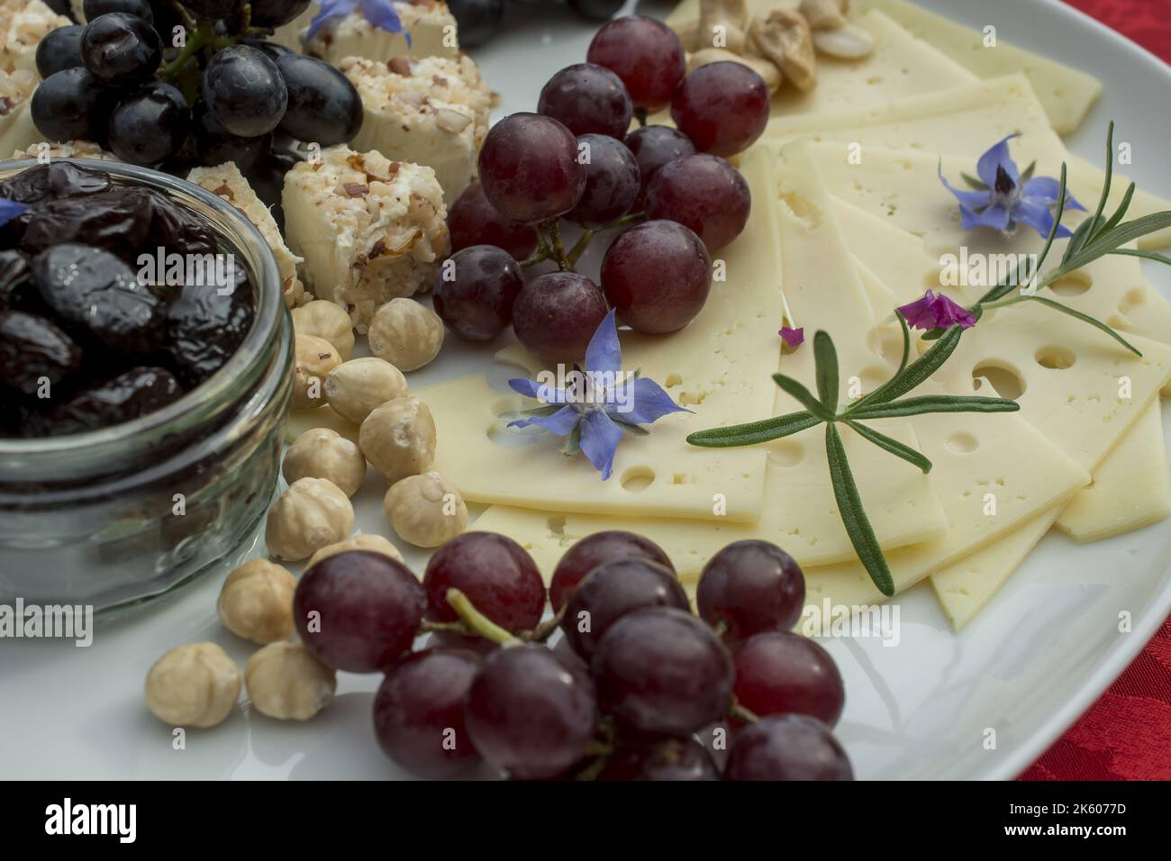 selezione di formaggi con uva e fiori commestibili Foto Stock
