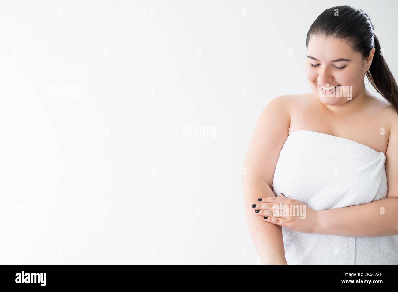 pelle sensibile felice donna curvy corpo idratante Foto Stock