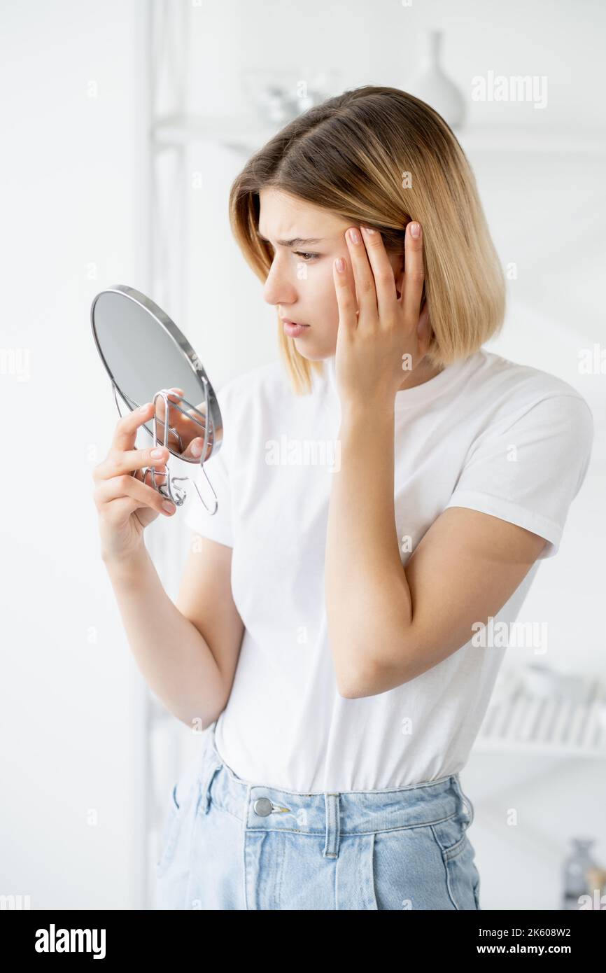 pelle invecchiamento dermatologia problema donna viso specchio Foto Stock