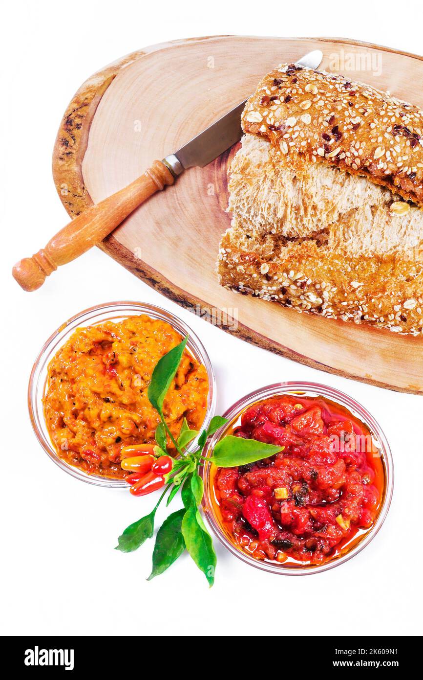 Il meze balcanico consiste di due tipi di pepe rosso spalmato, pane, noci, prosciutto ed erbe di stagione Foto Stock