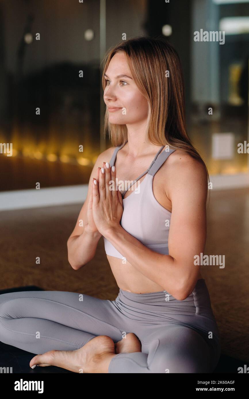 La ragazza fa yoga. Una donna in abbigliamento sportivo fa esercizi di yoga in palestra Foto Stock