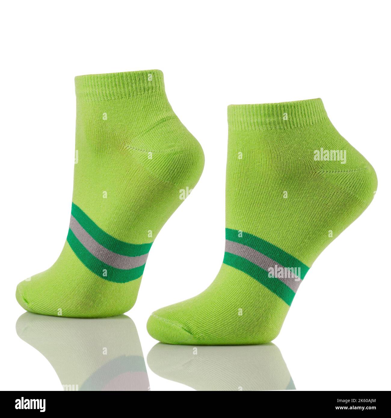 Primo piano di un paio di calze sportive in cotone sulle gambe invisibili isolate su fondo bianco. Set di calzini corti verdi per pubblicità, logo o posizionamento a caldo Foto Stock