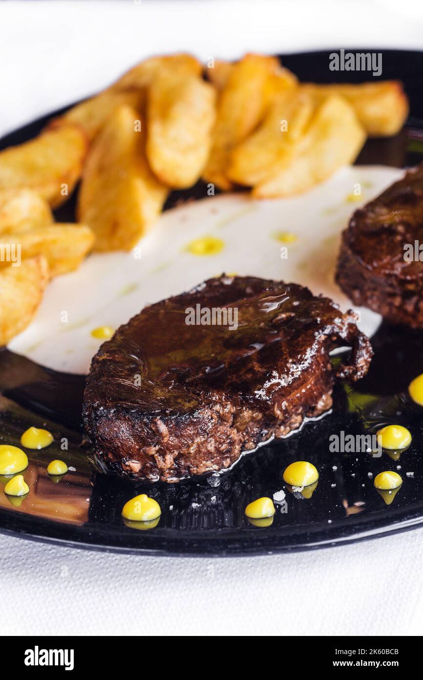 Tradizionale Naxian secco affinato carne di fieno sulla griglia servita con patate (fuoco selettivo) Foto Stock