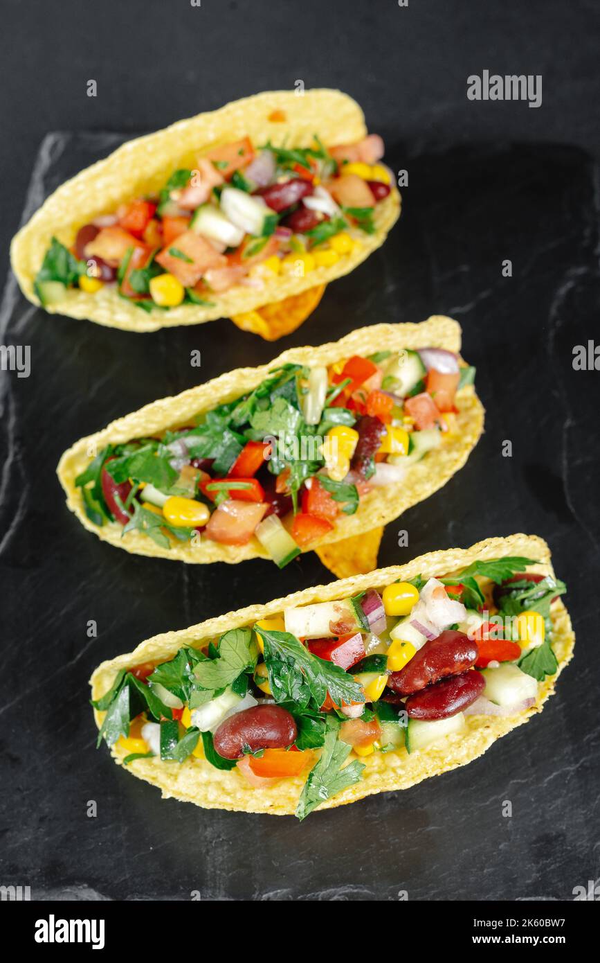 Tacos messicani con verdure su sfondo scuro su ardesia. Consumo Reducetarian, flexitarian, pescatarian. Vista dall'alto Foto Stock