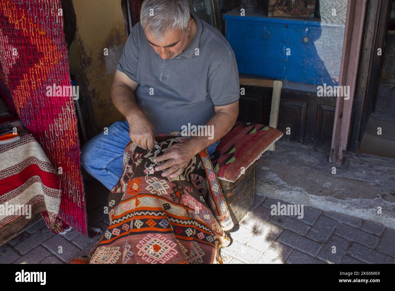 Bergama, Izmir, Turchia - 10.10.2022: Tessitura di tappeti uomo, tradizionale tappeto fatto a mano Foto Stock