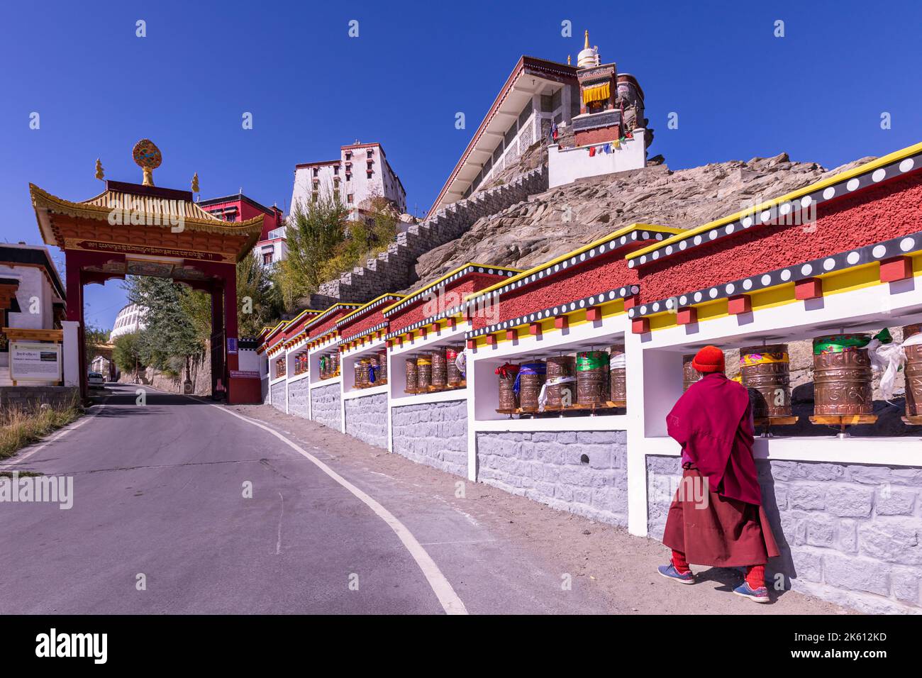 Un monaco che cammina verso il monastero di Thikse (Thiksay Gompa), Ladakh, India Foto Stock