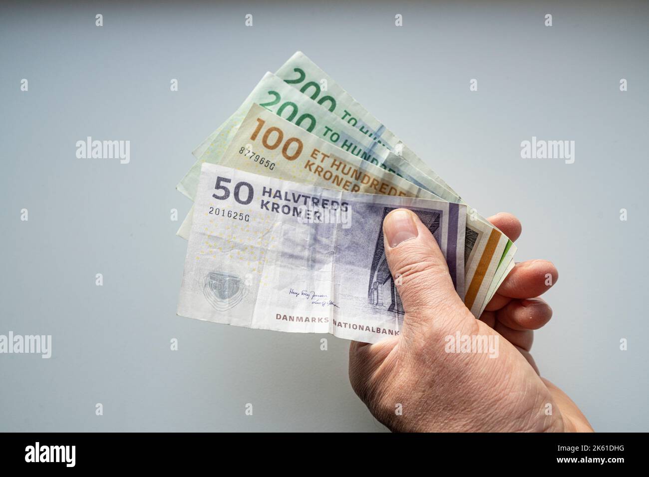 Alcune banconote in corona danese in mano maschile Foto Stock