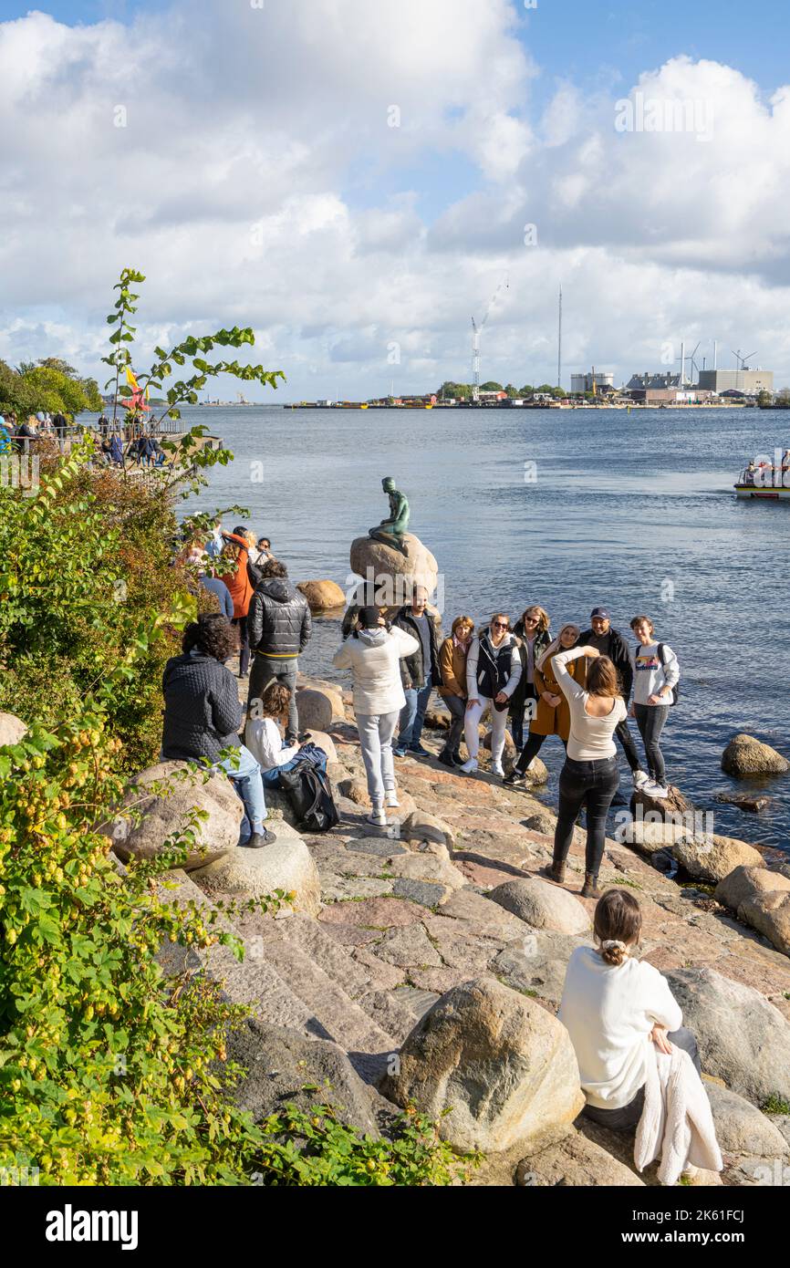 Copenaghen, Danimarca. Ottobre 2022. Un gruppo di turisti che scattano foto di fronte alla statua della sirena nel centro della città Foto Stock