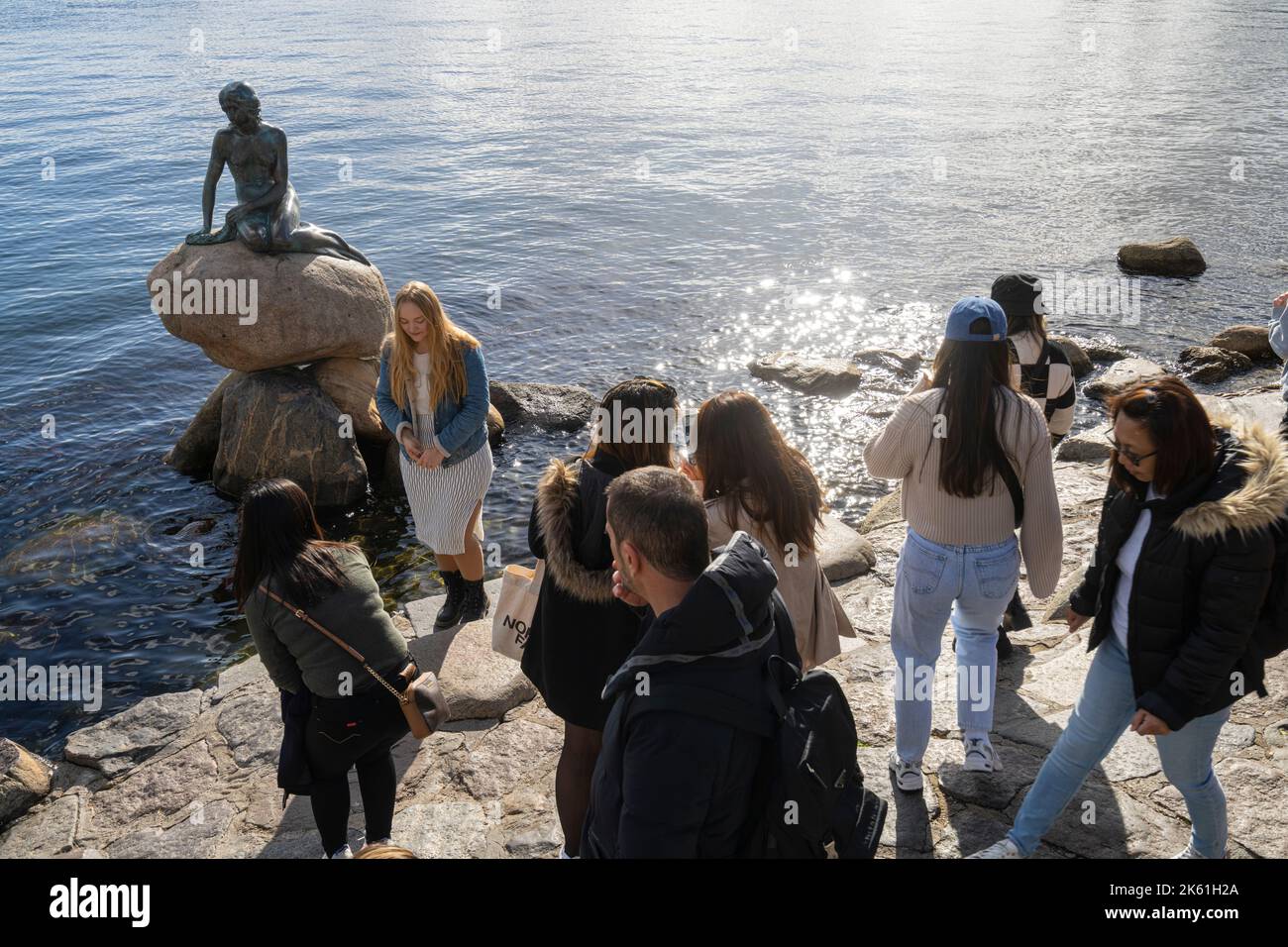 Copenaghen, Danimarca. Ottobre 2022. Un gruppo di turisti che scattano foto di fronte alla statua della sirena nel centro della città Foto Stock